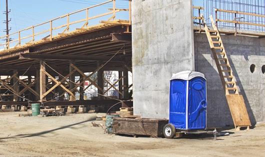 multiple porta potties arranged at a busy construction site